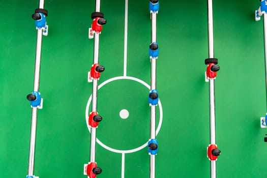 Table football. Top view of the football field and plastic players at a football match. red and blue players are hitting the ball. Championship