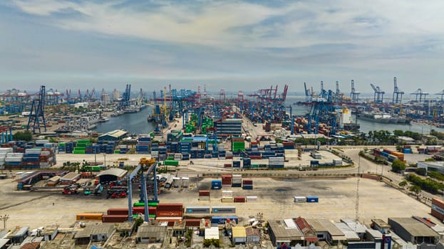 Jakarta, Indonesia - October 11, 2022: Aerial view of sea port with container ships and cranes in the loading area. Tanjung Priok sea port.