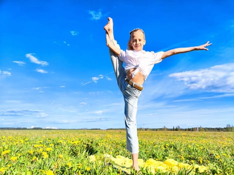 A flexible child showcases a stunning dance pose in a lush field filled with dandelions on a warm, sunny afternoon.