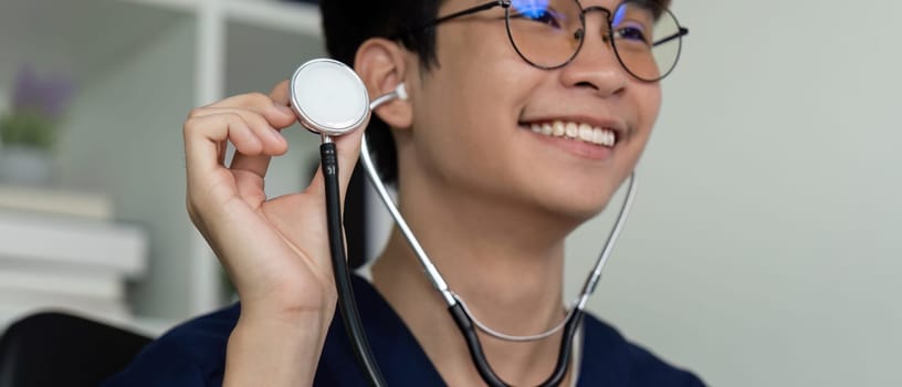 A joyful medical student with glasses holds a stethoscope, expressing passion for medicine and patient care.