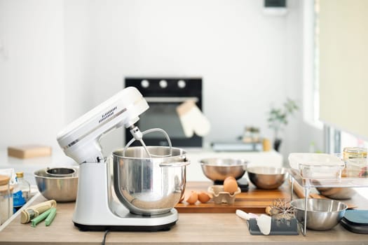 White stand mixer on a countertop surrounded by baking essentials and fresh ingredients.