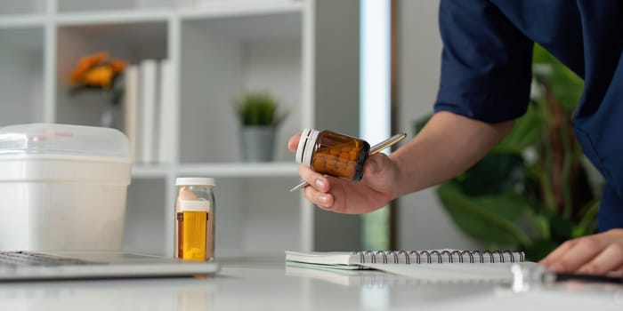 A thoughtful medical student reviews medication, emphasizing the importance of accuracy in healthcare.