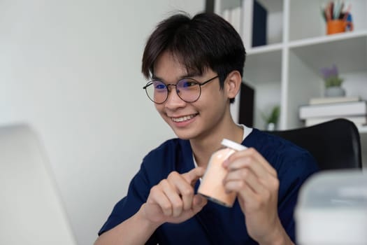 A cheerful medical student shows medication bottles during an online study session, reflecting enthusiasm for healthcare and learning.