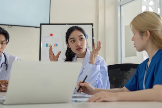 A diverse group of healthcare professionals engages in a meeting to analyze patient care strategies and improve outcomes.
