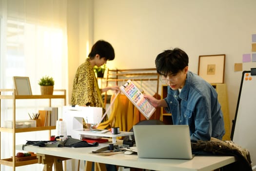 Fashion designers working on a creative project in stylish workspace.