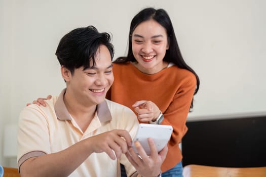 A couple happily reviews financial documents and bills, enhancing their budgeting skills and teamwork in managing finances.