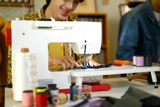 Close up of designer or tailor working on a sewing machine.