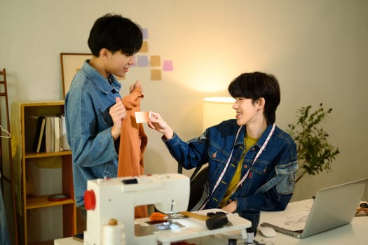 Team of fashion designers collaborating on new project in a studio.