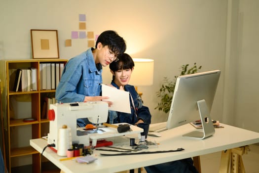 Fashion designers working on a creative project in stylish workspace.
