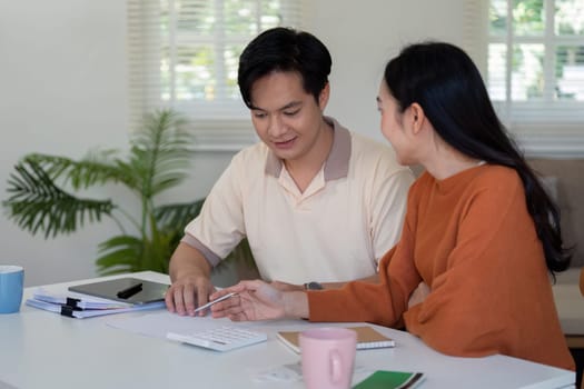 A couple engages in financial planning, calculating income and managing bills together, showcasing teamwork and responsibility.