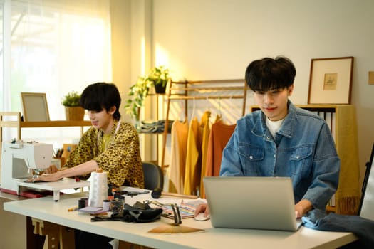 Fashion designers working on a creative project in stylish workspace.