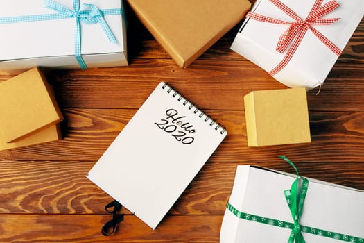 Prepare for Christmas with Notepad and gifts. Holiday decorations and notebook with wish list.