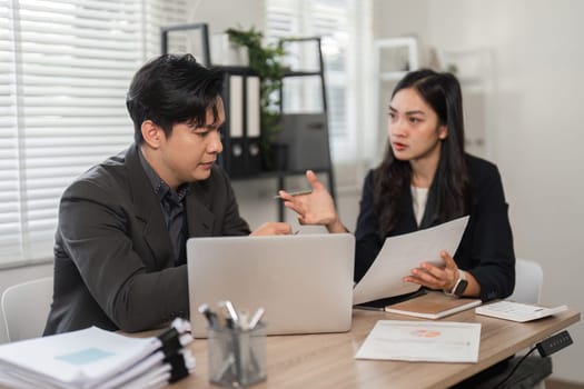 Two business partners review financial data and engage in strategic discussions in a modern office environment.