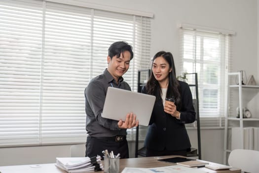 Two professionals discuss project progress, showcasing teamwork and collaboration in a bright office environment.