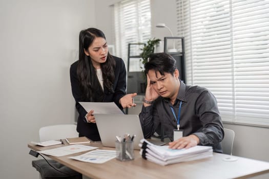 A woman expresses frustration to a man in an office setting, highlighting workplace challenges and communication issues.
