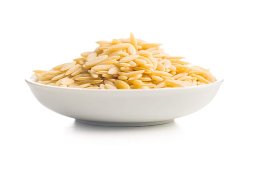 Orzo, kritharaki, risoni pasta. Uncooked dry pasta in bowl isolated on a white background.