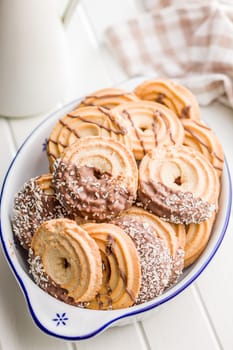 Sweet chocolate cookies in bowl on a white table.