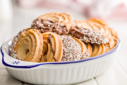 Sweet chocolate cookies in bowl on a white table.