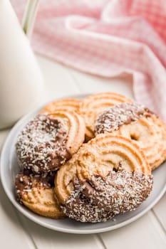 Sweet chocolate cookies on plate on a white table.