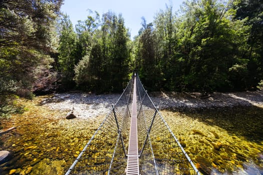Frenchmans Cap Suspended Bridge in Franklin-Gordon Wild Rivers National Park on a hot summer's day in Tasmania, Australia