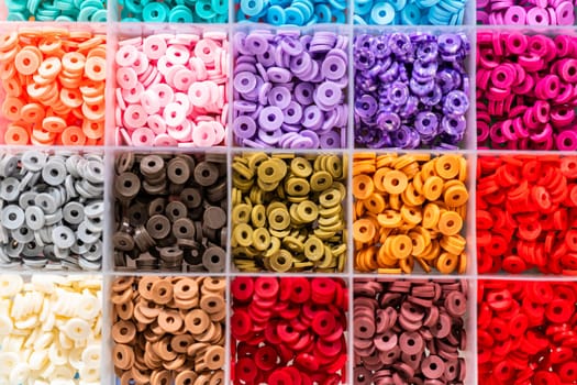 Assorted clay bead boxes neatly arranged on a white table, awaiting a creative kids' craft project.