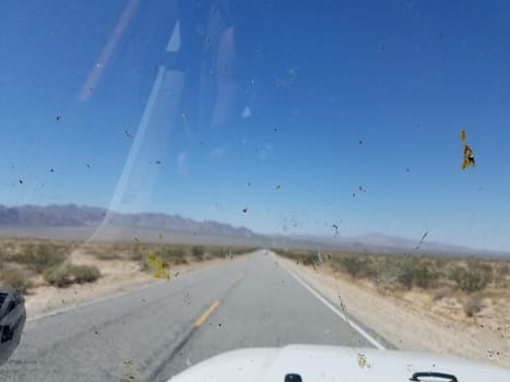 Looking Out through a Dirty Windshield on a Two Lane Desert Highway. High quality photo