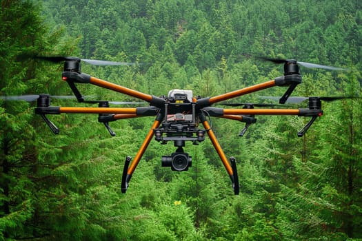 A drone flies above a dense forest, capturing the vibrant greenery and natural beauty under clear blue skies.