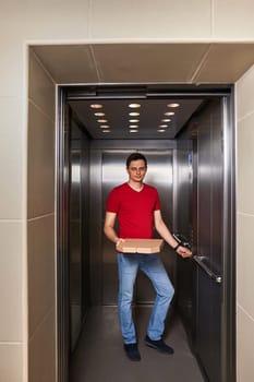 Deliveryman holding pizza box in elevator, food delivery to your home.