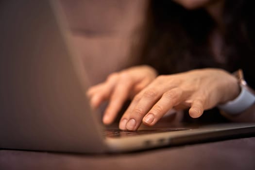 female hands typing on laptop computer on sofa, internet network communication