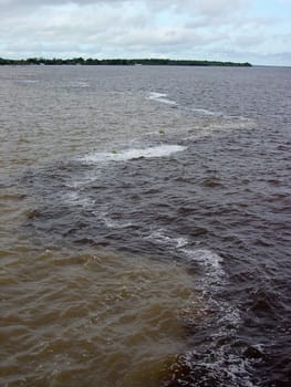 Confluence of the Amazons (left,brown water) and Rio Negro (right,dark water) near Manaus,Brazil