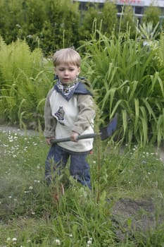 Boy playing in the garden with a shovel