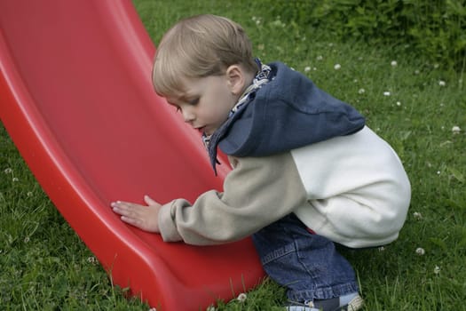Boy tries to see if the slide is wet