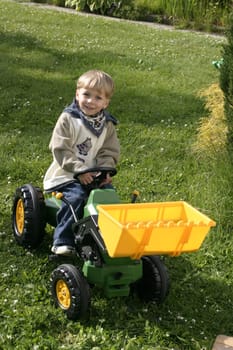 Boy honking his horn driving toy excavator