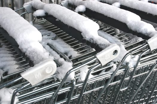 Snowfall on shopping carts . . .  gives cold,wet fingers . . .
