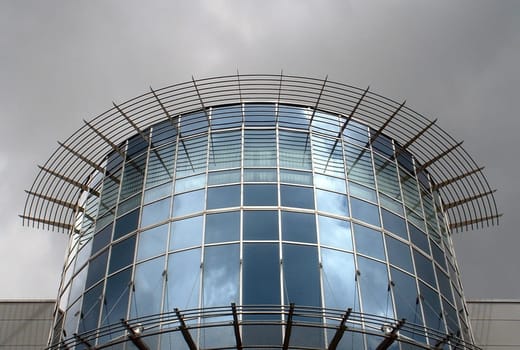 Detail of a cinema just before a downpour. However,the sun was still shining behind me at the time of the picture. Hence the illuminated glass front.