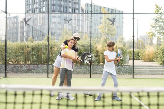 mother and daughters playing padel outdoor. High quality photo