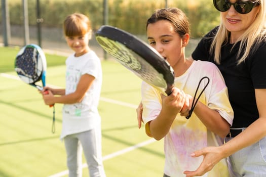 mother and children play paddle tennis. High quality photo