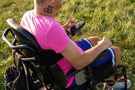 Homoxesual disabled man using joystick in electric wheelchair