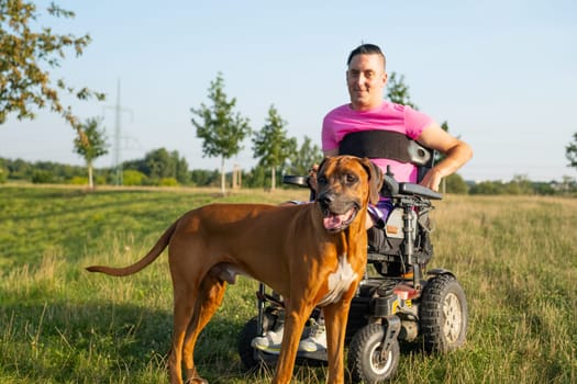 A person with a disability in a wheelchair accompanied by their service dog at the garden