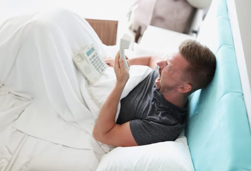 Man yells into phone in hotel room. Service in hotels and inns concept