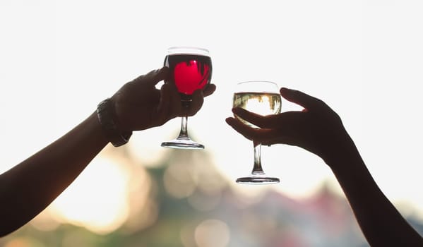 Men and women are holding glasses of red and white wine. Romantic date concept