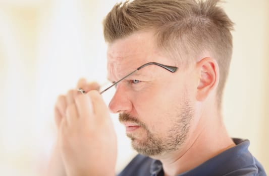 Portrait of concentrated male male taking off his glasses. Narcissistic man psychological portrait concept