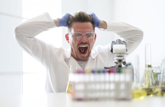 Research assistant looks enthusiastically at microscope. New discoveries in medicine concept