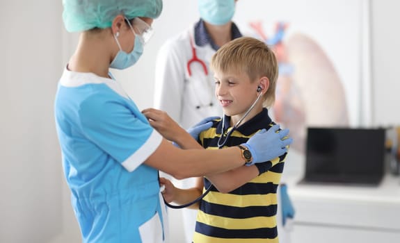 Child at doctor's appointment tries on stethoscope. Approach to children at pediatrician appointment concept