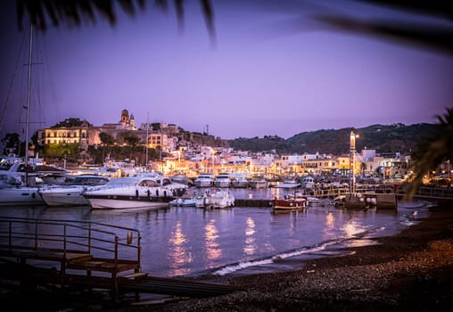 A harbor filled with lots of boats at night. Photo of a bustling harbor filled with illuminated boats at night in Sicily's Eolie Islands