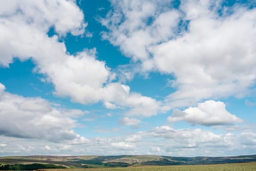 white cirrus, feathery clouds against spring bright blue cloudy sky on sunny day in England