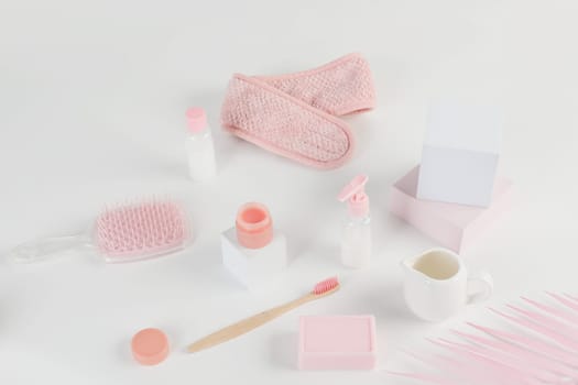 Skincare routine. Pink Women skincare products on white background. Soap, facial foam, cleansing, serum, cream lotion, toothbrush, lipstick. Beauty concept. Natural cosmetic pink flat lay top view.