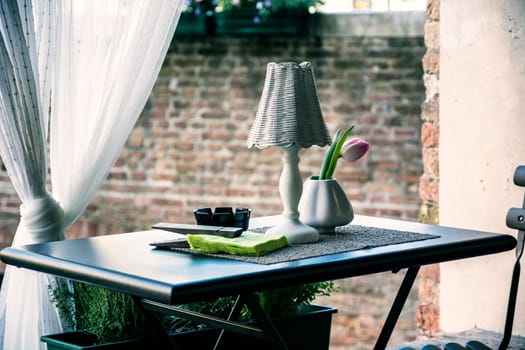 A table with a lamp and a vase on it. Photo of a beautifully decorated table with a lamp and vase as the centerpiece