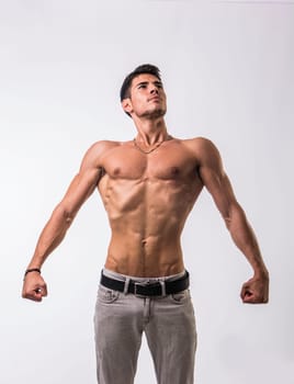 A man without a shirt posing for a picture. Photo of a shirtless man striking a pose for a captivating portrait in a funny, hero-like position