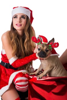 A woman in a santa claus outfit with a dog. Photo of a woman dressed in a Santa Claus outfit with her adorable dog
